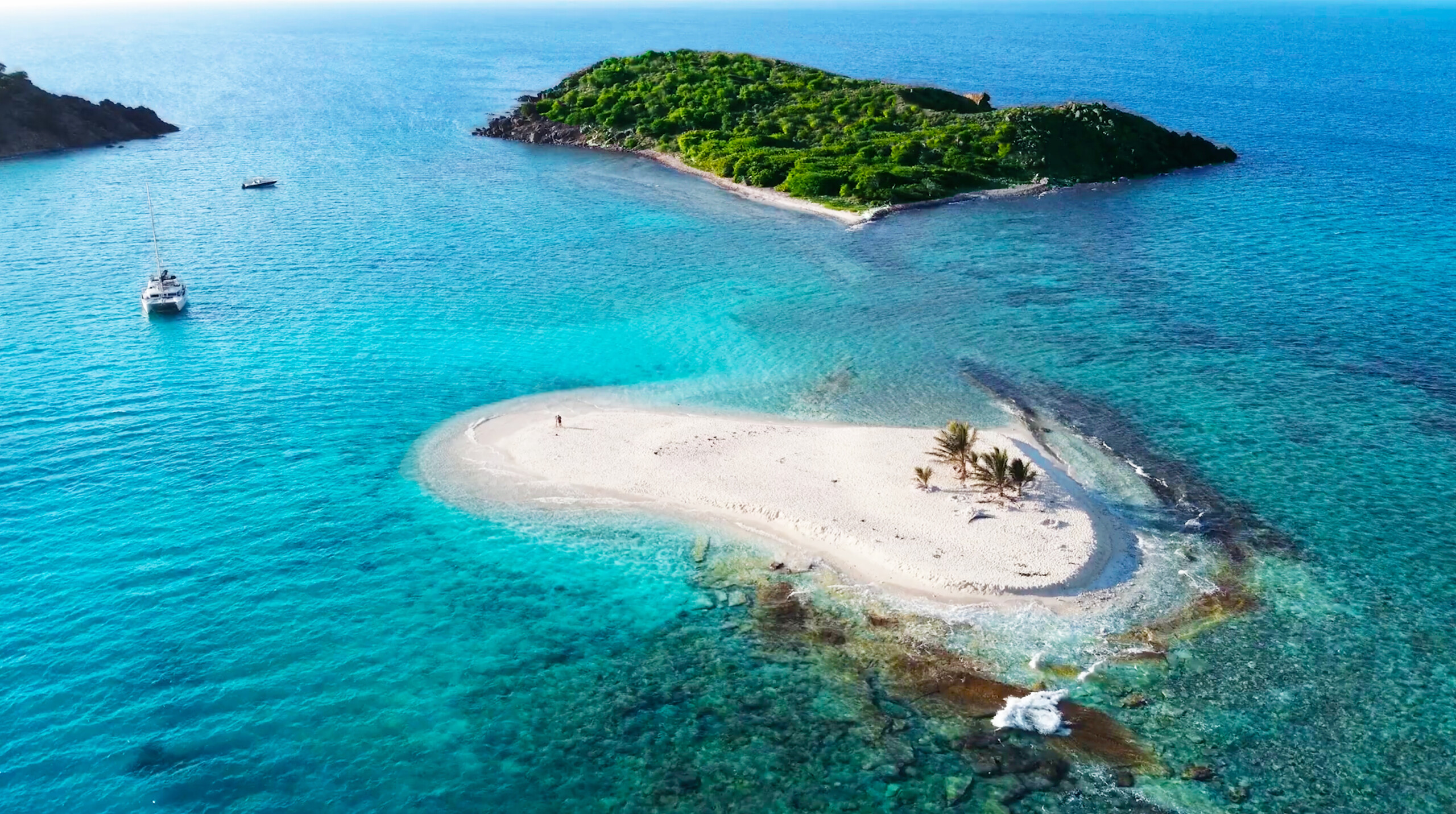 Tiny white sand island of Sandy Spit surrounded by turquoise Caribbean Sea