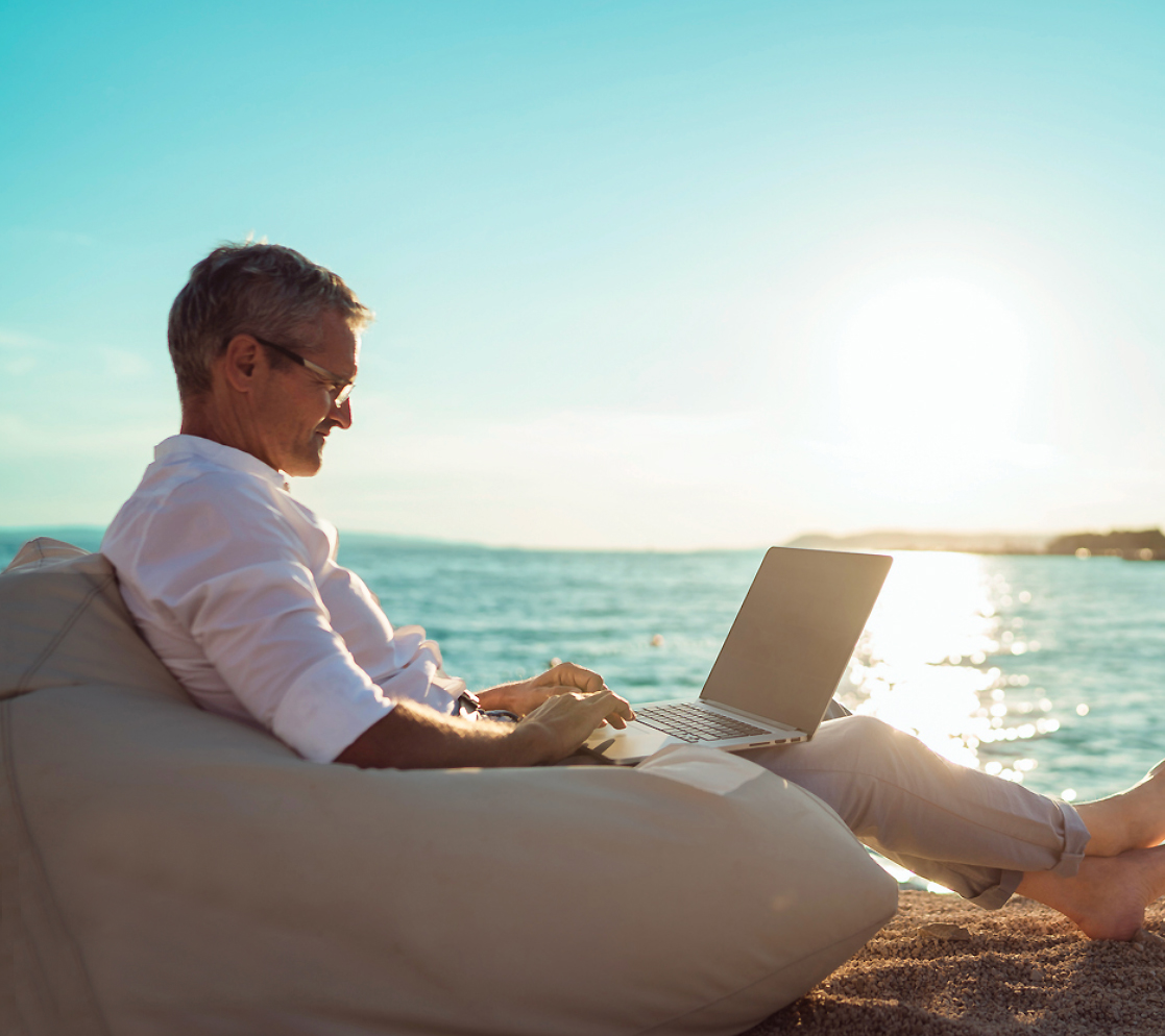 Corporate traveler working on a laptop beside the Caribbean Sea