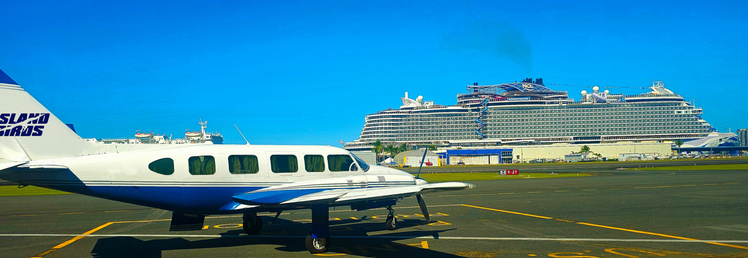 Island Birds Chieftain parked at Isla Grande Airport SIG in San Juan with a cruise ship visible behind the airport