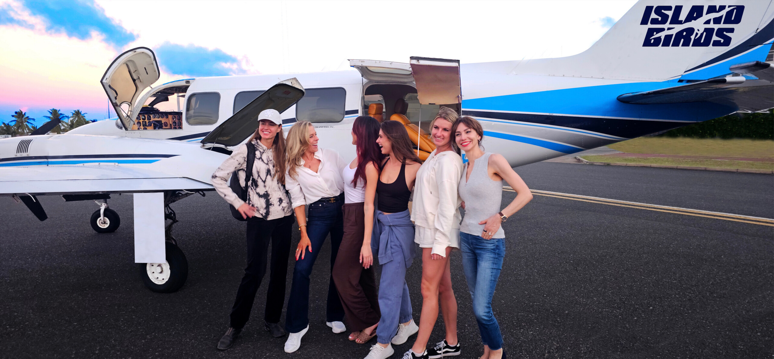 Happy friends preparing to board an Island Birds private charter aircraft